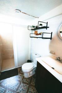 a bathroom with a white toilet and a sink at Otoch B&eacute;ek Calakmul in Chicanna