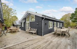 a black tiny house on a wooden deck at Stunning Home In Ebeltoft With Kitchen in Ebeltoft