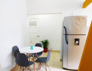 a kitchen with a table and a refrigerator at Cómodo Apartamento centro histórico 303-2 in Cartagena de Indias