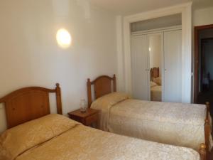 ein Hotelzimmer mit 2 Betten und einem Spiegel in der Unterkunft Sa Marina in Cala Millor