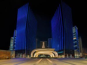 a building that is lit up in blue at night at EVEN Suzhou Grand Canal, an IHG Hotel in Suzhou