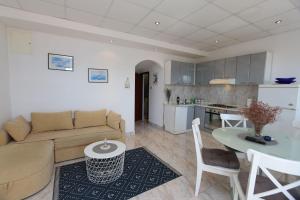 een woonkamer met een bank en een tafel en een keuken bij Apartment Lidija in Šilo