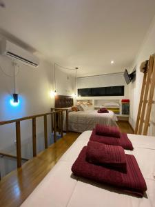 Un dormitorio con una cama con toallas rojas. en Belgrano 360, en Tandil
