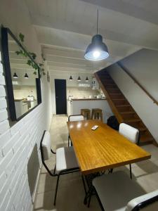 Un comedor con mesa y sillas de madera. en Belgrano 360, en Tandil