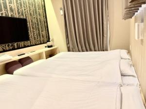 東京にあるホテルウィングインターナショナルセレクト浅草駒形のベッド2台、薄型テレビが備わるホテルルームです。
