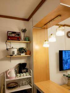 een keuken met een aanrecht en een tv en wat verlichting bij Catalena Transient House Bayugan City in Bayugan City