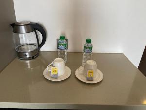 een tafel met twee kopjes en twee flessen water bij UPHILL HOTEL BAGUIO in Baguio