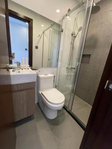 een badkamer met een toilet, een douche en een wastafel bij UPHILL HOTEL BAGUIO in Baguio
