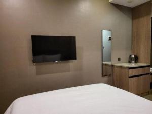 a bedroom with a bed and a flat screen tv at UPHILL HOTEL BAGUIO in Baguio