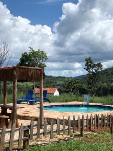 a swimming pool with a wooden fence around it at Recanto do Vale in Pirenópolis