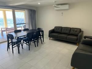 ein Wohnzimmer mit einem Tisch, Stühlen und einem Sofa in der Unterkunft Beachside & Jetty View Apartment 2 -Skippers Apartment in Streaky Bay