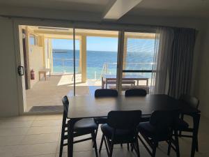 stół jadalny z krzesłami i widokiem na ocean w obiekcie Beachside & Jetty View Apartment 2 -Skippers Apartment w mieście Streaky Bay
