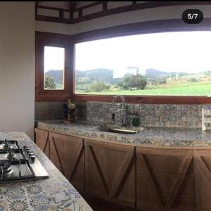 kuchnia z kuchenką, umywalką i oknem w obiekcie Villa Rosario w mieście Aquitania