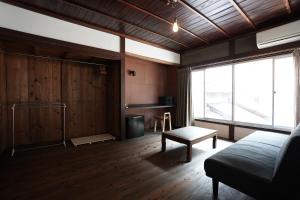a living room with a couch and a large window at 赭Soho Yunotsu Old Village Inn & Bar in Ōmorichō
