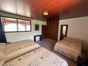 1 dormitorio con 2 camas y ventana en Villa Las Gemelas, en La Libertad