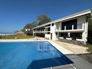 una casa con piscina frente a un edificio en Villa Las Gemelas, en La Libertad