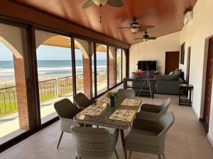 una sala de estar con mesa y sillas y el océano en Villa Las Gemelas, en La Libertad