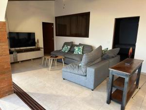 sala de estar con sofá y TV en Villa Las Gemelas, en La Libertad