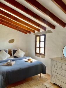 Un dormitorio con una cama con sábanas azules y una ventana. en BERGERIE PARADISU, Domaine de l Ogliastru, en Olmeto