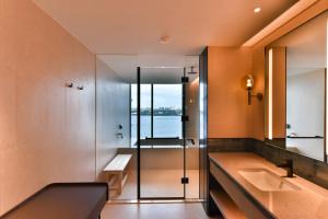 八里區的住宿－八里福朋喜來登酒店，带淋浴和盥洗盆的浴室