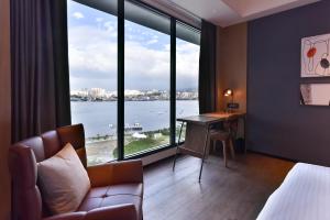 八里區的住宿－八里福朋喜來登酒店，酒店客房设有一张书桌和一个大窗户。