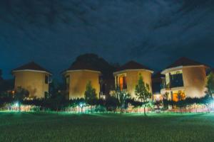 um grande edifício à noite com um relvado verde em Nile Village Hotel & Spa em Jinja