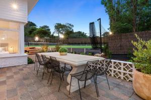 Sun Valley - Peaceful Portsea Escape في بورتسي: فناء مع طاولة وكراسي وملعب تنس