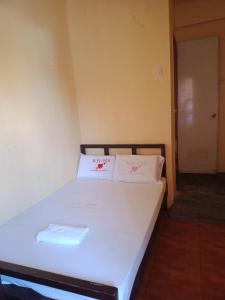 マンダウエ・シティにあるWJV INN Mandaue Centroの白い枕2つが備わるドミトリールームのベッド1台分です。