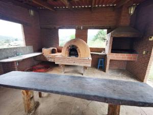 una cocina con horno de ladrillo en un edificio de ladrillo en Cabaña privada en Samaipata Getsemani JLO, en Samaipata