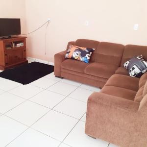 sala de estar con sofá marrón y TV en Casa# Cantinho do Sossego en São Francisco do Sul