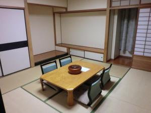 Habitación con mesa de madera y sillas. en Hiroshima International Youth House JMS Aster Plaza en Hiroshima