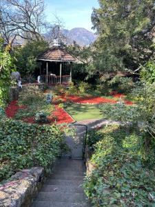 a garden with a gazebo and red flowers at Foothill House in Calistoga