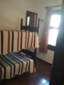 1 dormitorio con 1 cama con manta a rayas en Verano, en Punta del Este