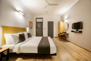 a hotel room with a large bed and a desk at OYO Townhouse 330 DLF Phase-2 Near Leisure Valley Park in Gurgaon