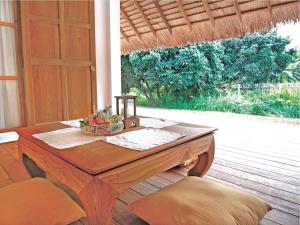 a wooden table with a bowl of fruit on it at resort hoshihana in Chiang Mai