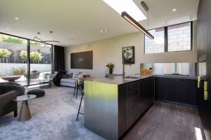 a kitchen and living room with a kitchen island in a house at Ivy Box Art Gallery Apartment in Queenstown