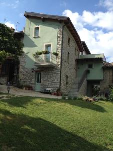 una casa in pietra con balcone e cortile di La Corte del Borgo a Valverde Pavia