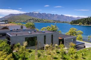 a house with a view of the water and mountains at Ivy Box Art Gallery Apartment in Queenstown