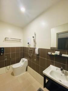 a bathroom with a sink and a toilet and a mirror at Hotel U and Me in Kulai