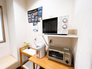 cocina con microondas y tostadora sobre una mesa en ビジネスホテル ごとう＠ＮＥＴ, en Kure