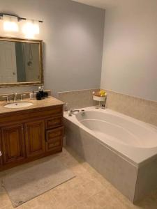a bathroom with a large white tub and a sink at Sweet home in Ottawa