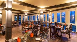 un ristorante con tavoli, sedie e finestre di Cheltenham Cottage - Little England Cottages a Nuwara Eliya
