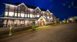 a large house with lights on a street at night at Cheltenham Cottage - Little England Cottages in Nuwara Eliya