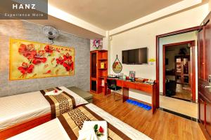 Cette chambre comprend un lit et un bureau. dans l'établissement HANZ Cao Gia Hai Hotel, à Hô-Chi-Minh-Ville