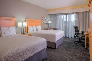a hotel room with two beds and a desk at Courtyard by Marriott Sandestin at Grand Boulevard in Destin