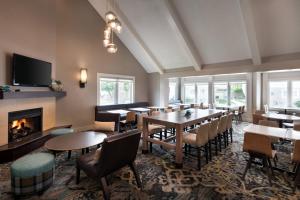 a restaurant with tables and chairs and a fireplace at Residence Inn by Marriott Boulder in Boulder