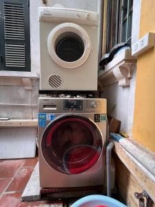 a washing machine with a microwave on top of it at French-styled house in Hanoi