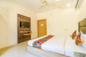 1 dormitorio con 2 camas y TV en la pared en FabHotel Royal Aanandam, en Gwalior