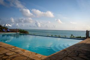 a swimming pool with the ocean in the background at SULTAN PALACE in Michamvi