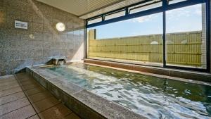 una piscina en un edificio con una ventana grande en Hotel Sunmi Club Bekkan en Atami